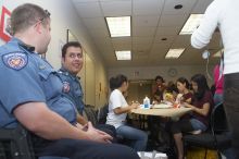 Officers Wesley Schlather and Joshua Martin observe students decorating masks at a domestic violence expressive arts workshop for survivors and friends of survivors of domestic and relationship violence.

Filename: SRM_20061023_1732064.jpg
Aperture: f/5.6
Shutter Speed: 1/100
Body: Canon EOS 20D
Lens: Canon EF-S 18-55mm f/3.5-5.6