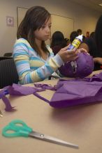 Mae Cortes decorates her mask at a domestic violence expressive arts workshop for survivors and friends of survivors of domestic and relationship violence.

Filename: SRM_20061023_1736104.jpg
Aperture: f/5.6
Shutter Speed: 1/100
Body: Canon EOS 20D
Lens: Canon EF-S 18-55mm f/3.5-5.6