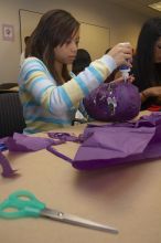 Mae Cortes decorates her mask at a domestic violence expressive arts workshop for survivors and friends of survivors of domestic and relationship violence.

Filename: SRM_20061023_1736166.jpg
Aperture: f/5.6
Shutter Speed: 1/100
Body: Canon EOS 20D
Lens: Canon EF-S 18-55mm f/3.5-5.6