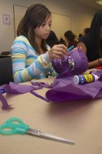 Mae Cortes decorates her mask at a domestic violence expressive arts workshop for survivors and friends of survivors of domestic and relationship violence.

Filename: SRM_20061023_1736187.jpg
Aperture: f/5.6
Shutter Speed: 1/100
Body: Canon EOS 20D
Lens: Canon EF-S 18-55mm f/3.5-5.6