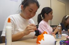 Hannah Yee, with Diane Nguyen, painting their masks at a domestic violence expressive arts workshop for survivors and friends of survivors of domestic and relationship violence.

Filename: SRM_20061023_1741163.jpg
Aperture: f/5.6
Shutter Speed: 1/100
Body: Canon EOS 20D
Lens: Canon EF-S 18-55mm f/3.5-5.6