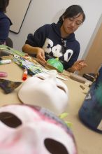 Stephanie Luu, with Hannah Jones' mask in the foreground.  Domestic violence expressive arts workshop for survivors and friends of survivors of domestic and relationship violence.

Filename: SRM_20061023_1800127.jpg
Aperture: f/5.6
Shutter Speed: 1/100
Body: Canon EOS 20D
Lens: Canon EF-S 18-55mm f/3.5-5.6