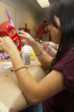 Emily Ng finishing up her mask at a domestic violence expressive arts workshop for survivors and friends of survivors of domestic and relationship violence.

Filename: SRM_20061023_1806005.jpg
Aperture: f/5.6
Shutter Speed: 1/100
Body: Canon EOS 20D
Lens: Canon EF-S 18-55mm f/3.5-5.6