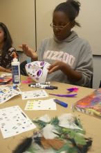 Vimbai Madzura decorates a mask to express herself at a domestic violence expressive arts workshop for survivors and friends of survivors of domestic and relationship violence.

Filename: SRM_20061023_1809002.jpg
Aperture: f/5.6
Shutter Speed: 1/100
Body: Canon EOS 20D
Lens: Canon EF-S 18-55mm f/3.5-5.6