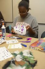 Vimbai Madzura decorates a mask to express herself at a domestic violence expressive arts workshop for survivors and friends of survivors of domestic and relationship violence.

Filename: SRM_20061023_1809043.jpg
Aperture: f/5.6
Shutter Speed: 1/100
Body: Canon EOS 20D
Lens: Canon EF-S 18-55mm f/3.5-5.6