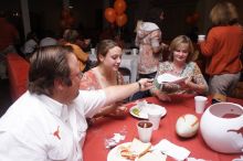 Haley Lyons and her parents sign the Kappa house leasing contract.  Kappa Kappa Gamma (KKG) hosted a parents' weekend barbecue before the UT vs Nebraska football game on Saturday, October 27, 2007 at their sorority house.

Filename: SRM_20071027_1205444.jpg
Aperture: f/8.0
Shutter Speed: 1/250
Body: Canon EOS 20D
Lens: Canon EF-S 18-55mm f/3.5-5.6