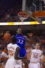 KU senior Darnell Jackson (#32, Forward) dunks over UT freshman Alexis Wangmene (#15, F/C) and UT junior Connor Atchley (#32, F/C).  The University of Texas (UT) Longhorns defeated the University of Kansas Jayhawks 72-69 in Austin, Texas on Monday, February 11, 2008.

Filename: SRM_20080211_2046144.jpg
Aperture: f/2.8
Shutter Speed: 1/640
Body: Canon EOS-1D Mark II
Lens: Canon EF 80-200mm f/2.8 L