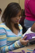 Mae Cortes decorates her mask at a domestic violence expressive arts workshop for survivors and friends of survivors of domestic and relationship violence.

Filename: SRM_20061023_1733145.jpg
Aperture: f/5.6
Shutter Speed: 1/100
Body: Canon EOS 20D
Lens: Canon EF-S 18-55mm f/3.5-5.6