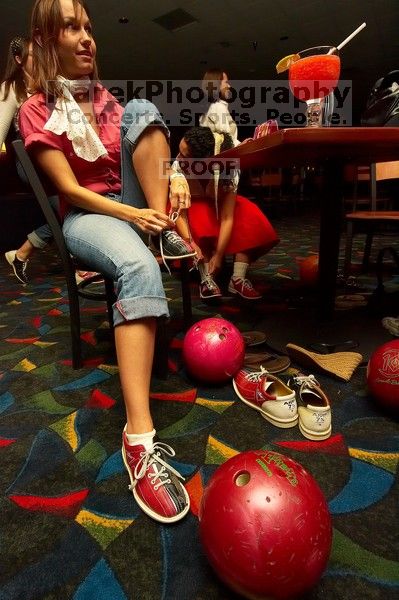 Jessica Schreyer laces up for bowling.  Alpha Xi Delta held a sock hop themed date night at the Austin 300 bowling alley, Thursday night, March 29, 2007.

Filename: SRM_20070329_2019481.jpg
Aperture: f/8.0
Shutter Speed: 1/200
Body: Canon EOS-1D Mark II
Lens: Sigma 15-30mm f/3.5-4.5 EX Aspherical DG DF
