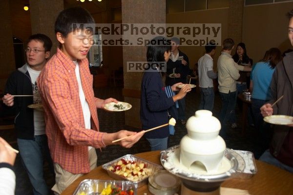Xu Liang.  The Asian Business Students Association (ABSA) hosted a chocolate fondue Friday, January 26, 2007 before heading off to a movie premier.

Filename: SRM_20070126_1617069.jpg
Aperture: f/4.5
Shutter Speed: 1/160
Body: Canon EOS 20D
Lens: Canon EF-S 18-55mm f/3.5-5.6
