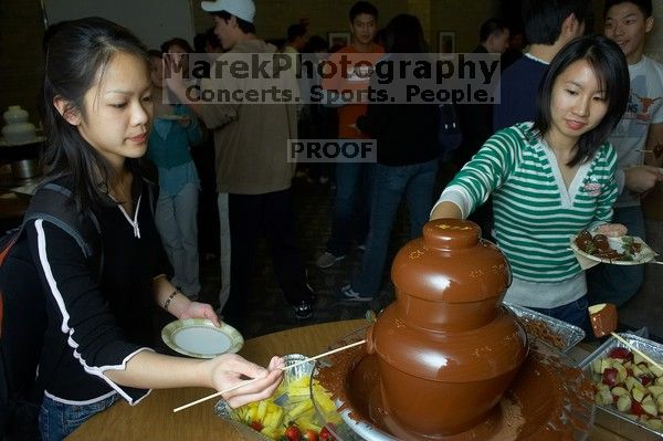 Monica Nguyen and Jacqueline So.  The Asian Business Students Association (ABSA) hosted a chocolate fondue Friday, January 26, 2007 before heading off to a movie premier.

Filename: SRM_20070126_1659423.jpg
Aperture: f/5.6
Shutter Speed: 1/160
Body: Canon EOS 20D
Lens: Canon EF-S 18-55mm f/3.5-5.6
