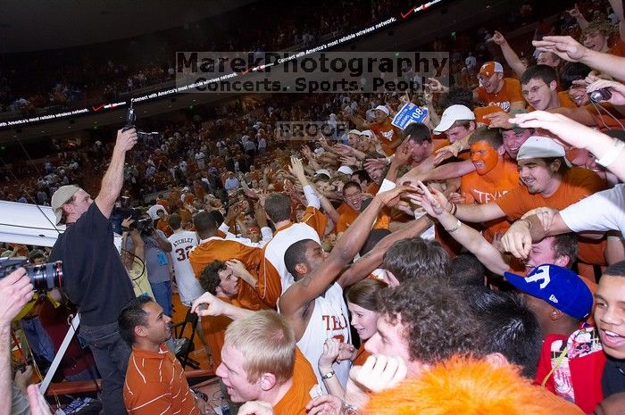 The fans react to the Longhorns' win, shaking hands with UT sophomore Justin Mason (#24, G) and other players.  The University of Texas (UT) Longhorns defeated the University of Kansas Jayhawks 72-69 in Austin, Texas on Monday, February 11, 2008.

Filename: SRM_20080211_2219269.jpg
Aperture: f/5.6
Shutter Speed: 1/250
Body: Canon EOS-1D Mark II
Lens: Canon EF 16-35mm f/2.8 L