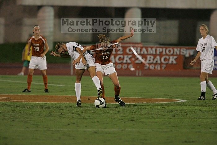 UT freshman Kylie Doniak (#15, Midfielder) tackles the ball as UT sophomore Erica Campanelli (#19, Defender) watches.  The University of Texas women's soccer team tied 0-0 against the Texas A&M Aggies Friday night, September 27, 2008.

Filename: SRM_20080926_1942065.jpg
Aperture: f/4.0
Shutter Speed: 1/500
Body: Canon EOS-1D Mark II
Lens: Canon EF 300mm f/2.8 L IS