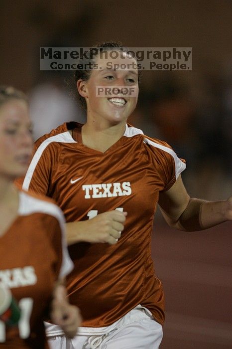 UT senior Kasey Moore (#14, Defender) running back to the team benches before the second half.  The University of Texas women's soccer team tied 0-0 against the Texas A&M Aggies Friday night, September 27, 2008.

Filename: SRM_20080926_2000524.jpg
Aperture: f/2.8
Shutter Speed: 1/500
Body: Canon EOS-1D Mark II
Lens: Canon EF 300mm f/2.8 L IS