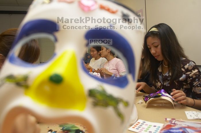 Through the eyes of Rita Saynhalath's mask, from the right, Christine Achico, Diane Nguyen, and Hannah Yee at a domestic violence expressive arts workshop for survivors and friends of survivors of domestic and relationship violence.

Filename: SRM_20061023_1810085.jpg
Aperture: f/5.6
Shutter Speed: 1/100
Body: Canon EOS 20D
Lens: Canon EF-S 18-55mm f/3.5-5.6
